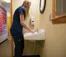 A picture of a women in a blue shirt washing her hands