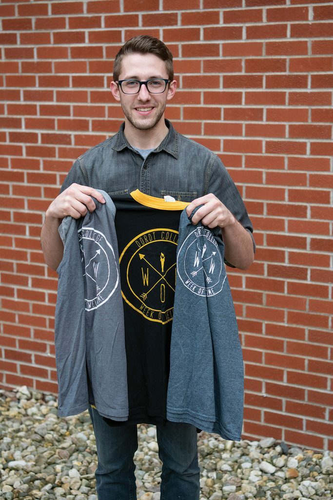 A picture of a man holding a week of welcome jacket