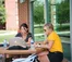 A picture of two women working on their laptops outside