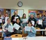 A group of students and faculty hold up their coloring pages