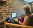 A picture of a women in the West hall lodge working on her laptop