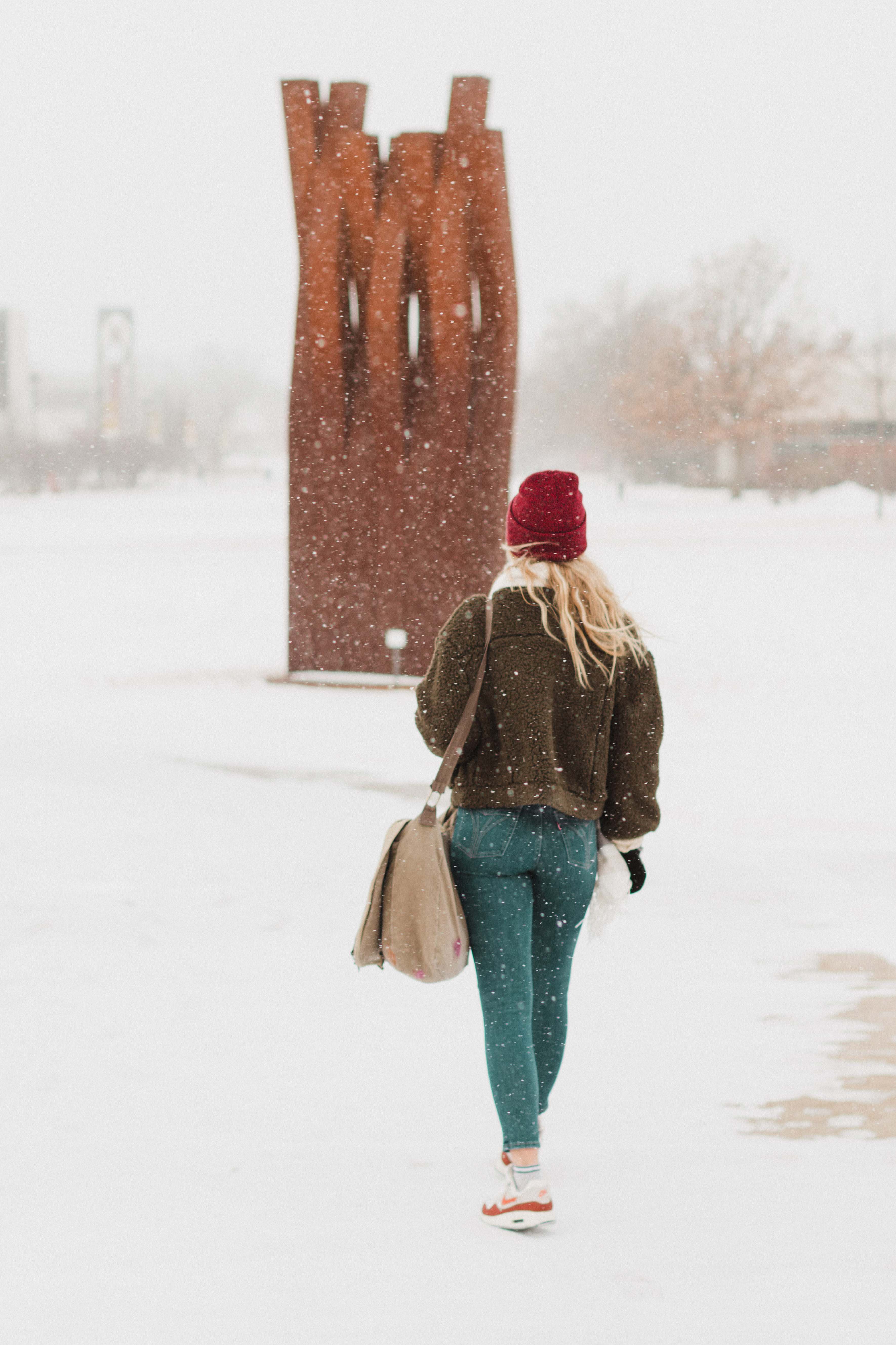 A picture of a woman walking around campus in the snow