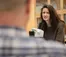 A picture of a woman sitting in front of a microscope looking at a man