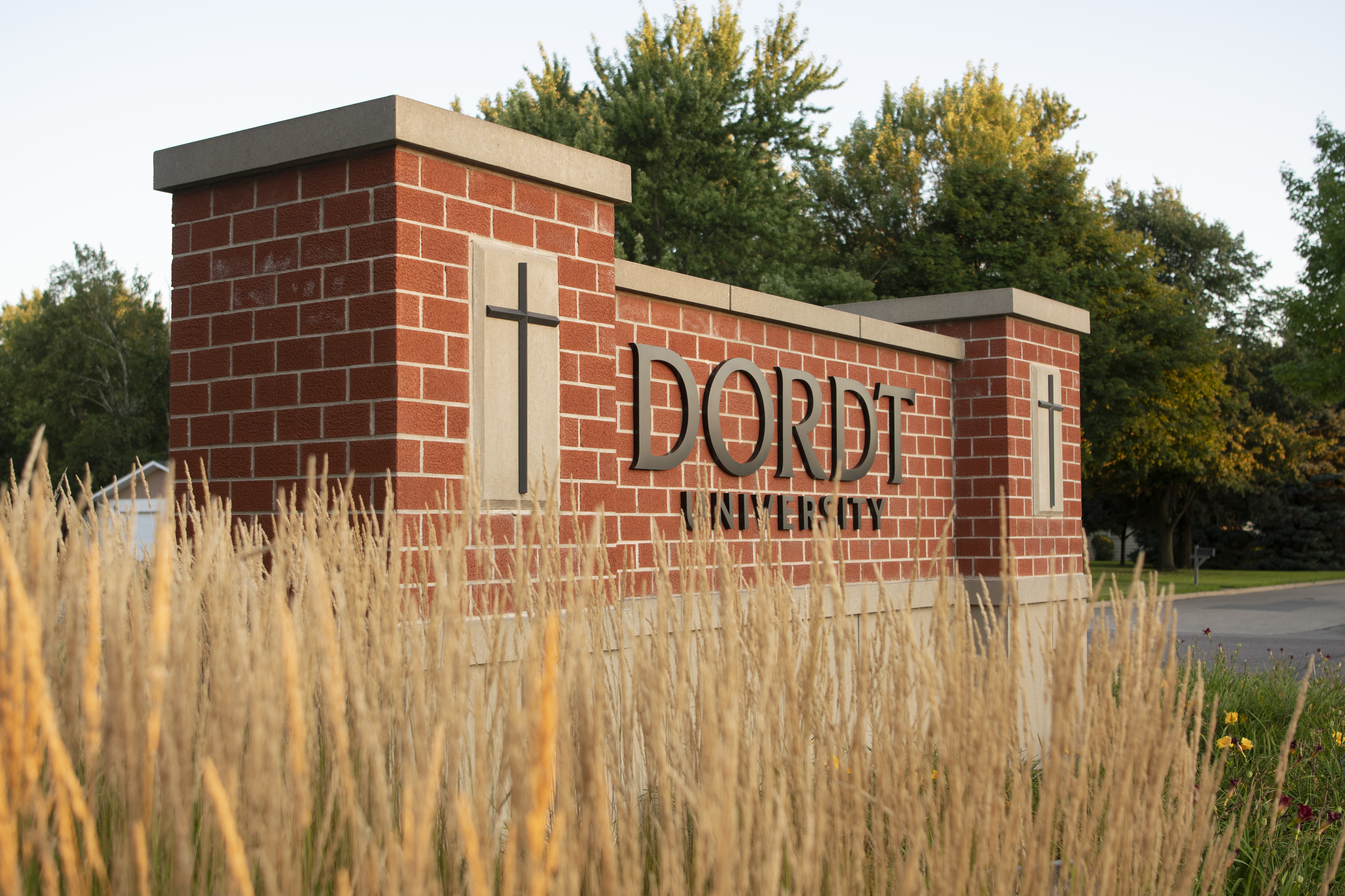 Dordt's front entry signage of a brick pedestal with Dordt University in black letters on it