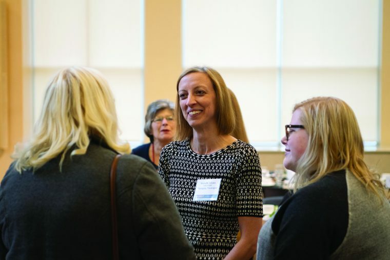 A smiling women talks to the people around her