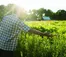 A person in a plaid shirt gestures to the prairie