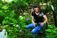 A picture of a woman holding two jars in the woods