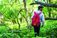 A picture of a man with a red backpack walking through the woods