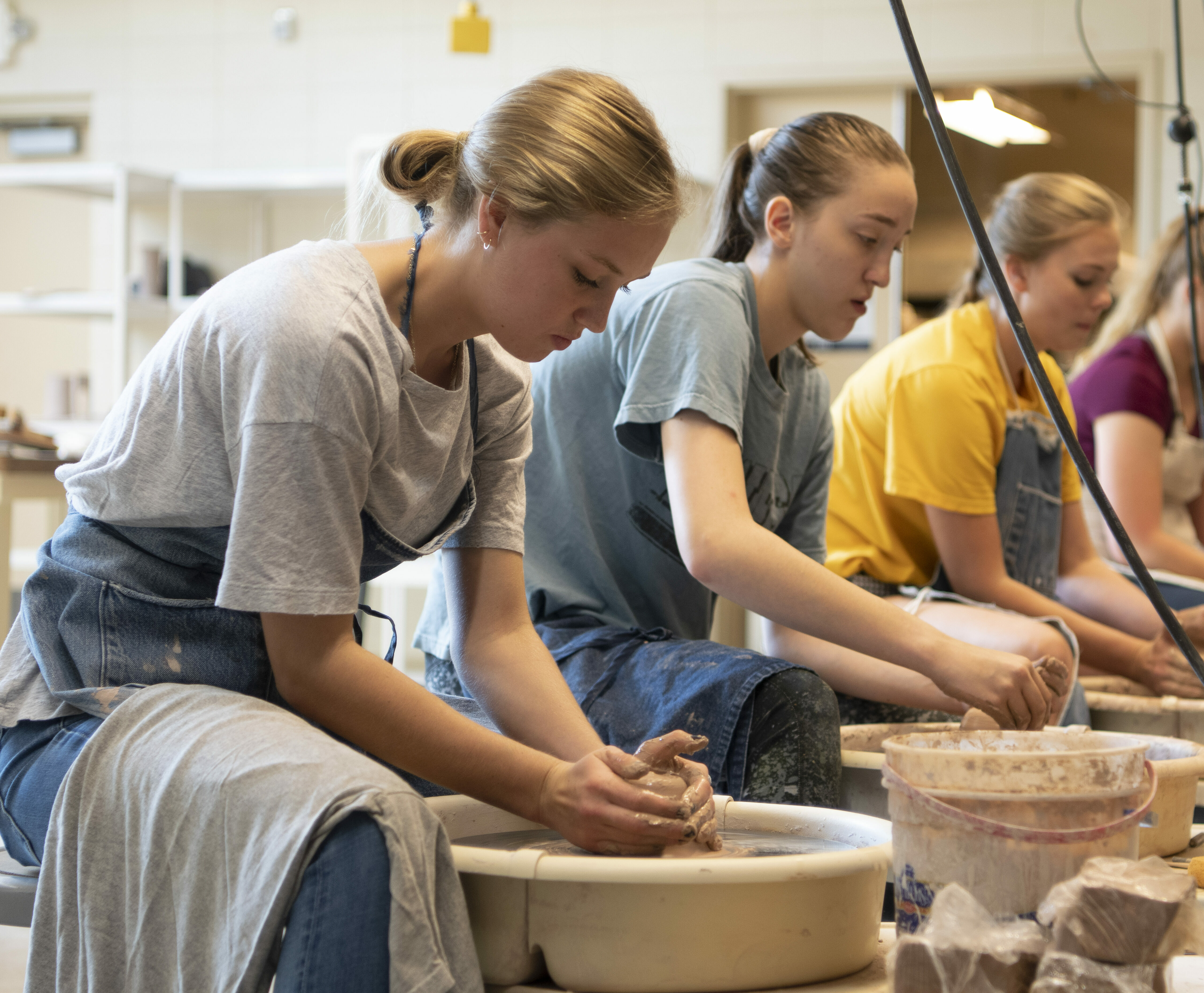 Female students working on pottery wheels