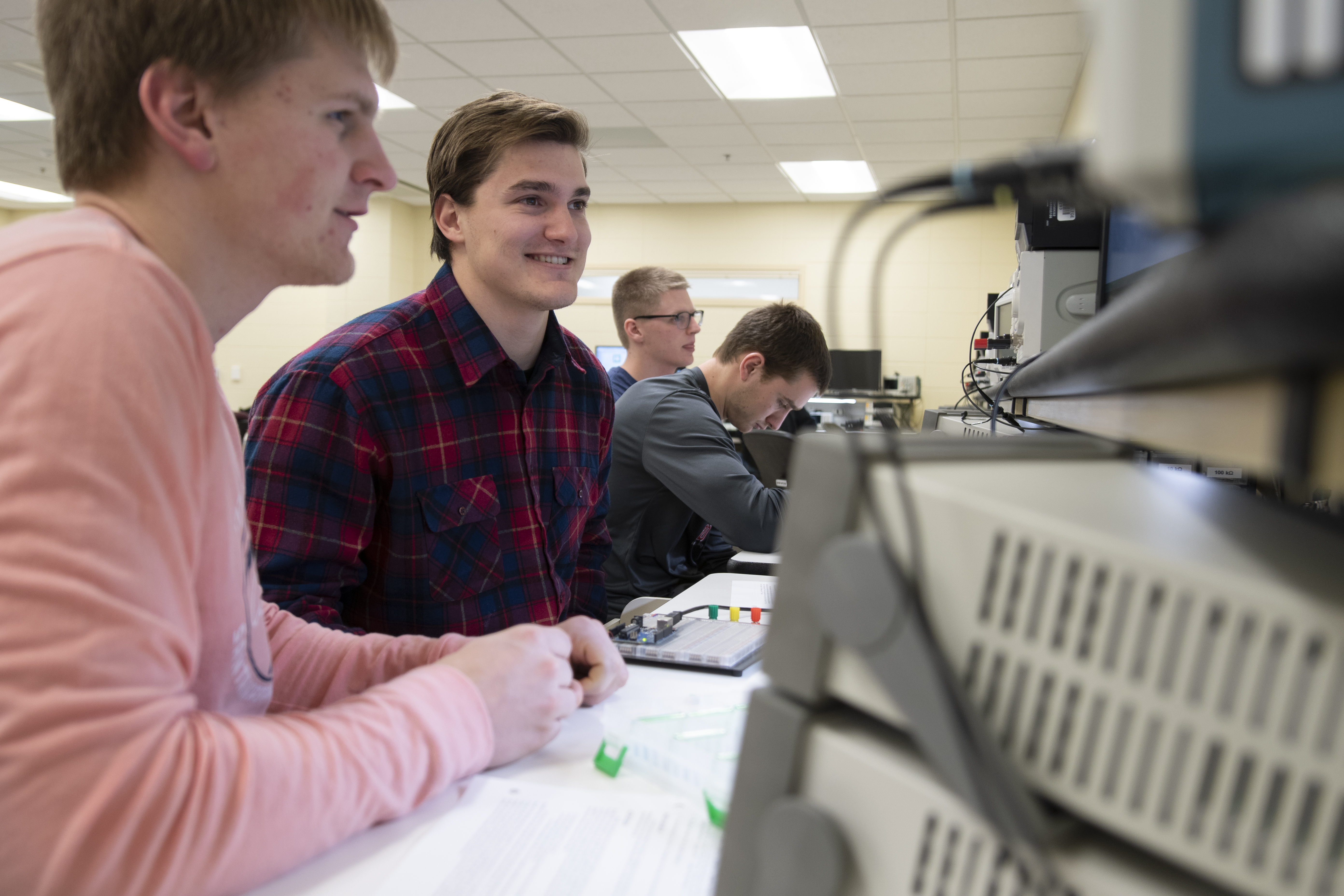 Male students look at a screen in an electrical lab