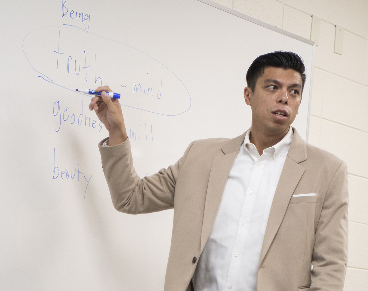 Male instructor pointing at whiteboard with marker