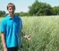 A person in a blue polo stands in the prairie