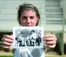 A picture of a student holding a black and white photo for the camera