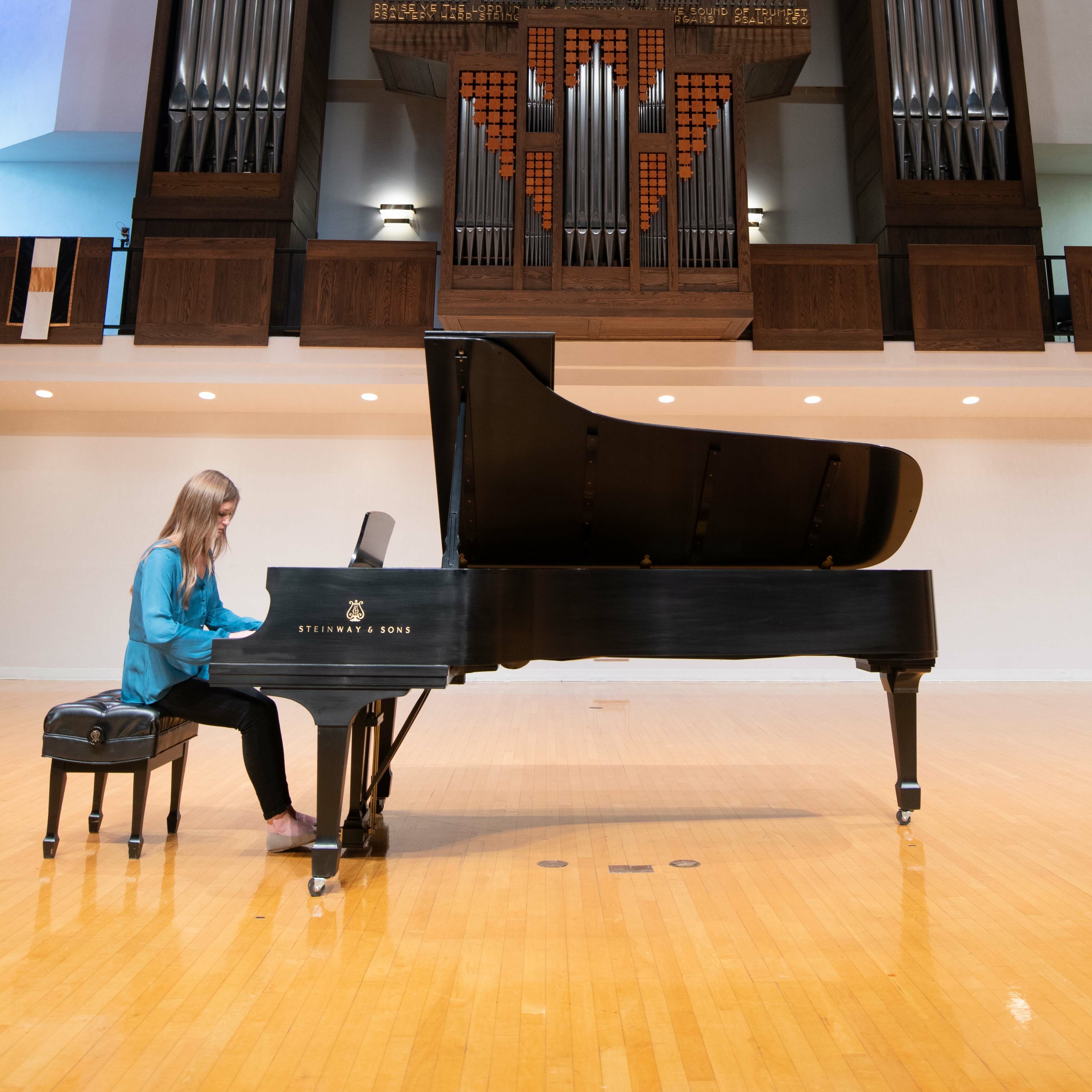 Female student plays Steinway piano on stage