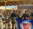 A picture of soldiers standing in a line holding a flag and their guns
