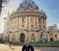 A picture of a student in front of an old building