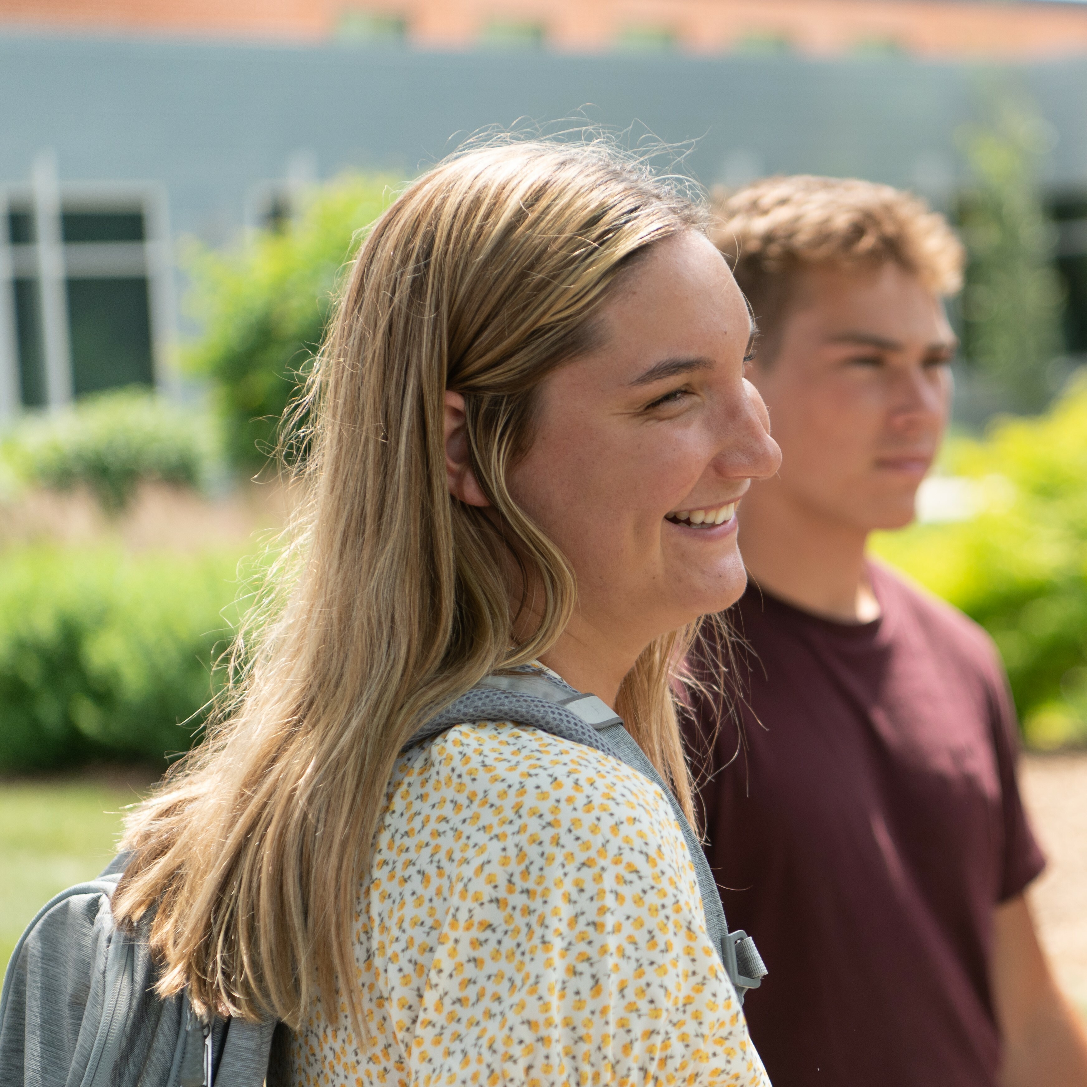 A picture of a smiling student walking to class.