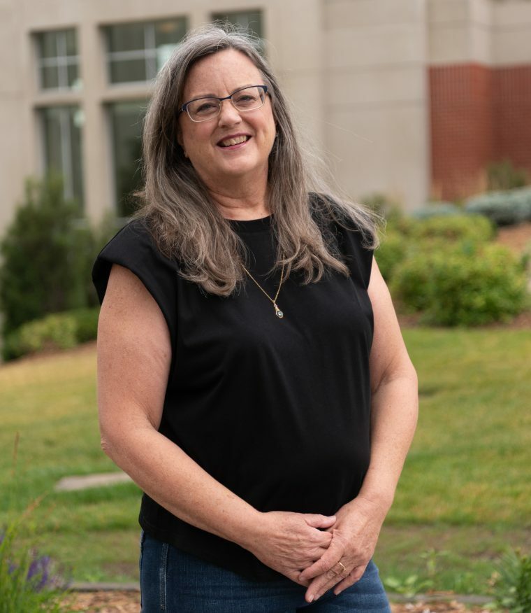 A women with brown hair smiles