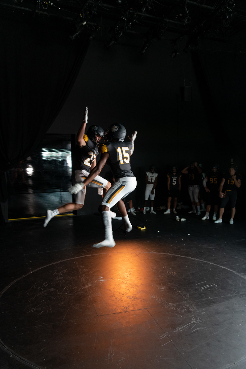 Two Dordt football players jump for a high five