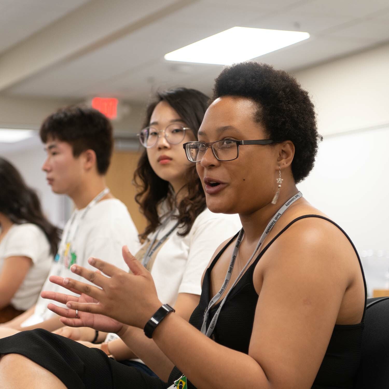 A female student speaks using her hands at international student orientation