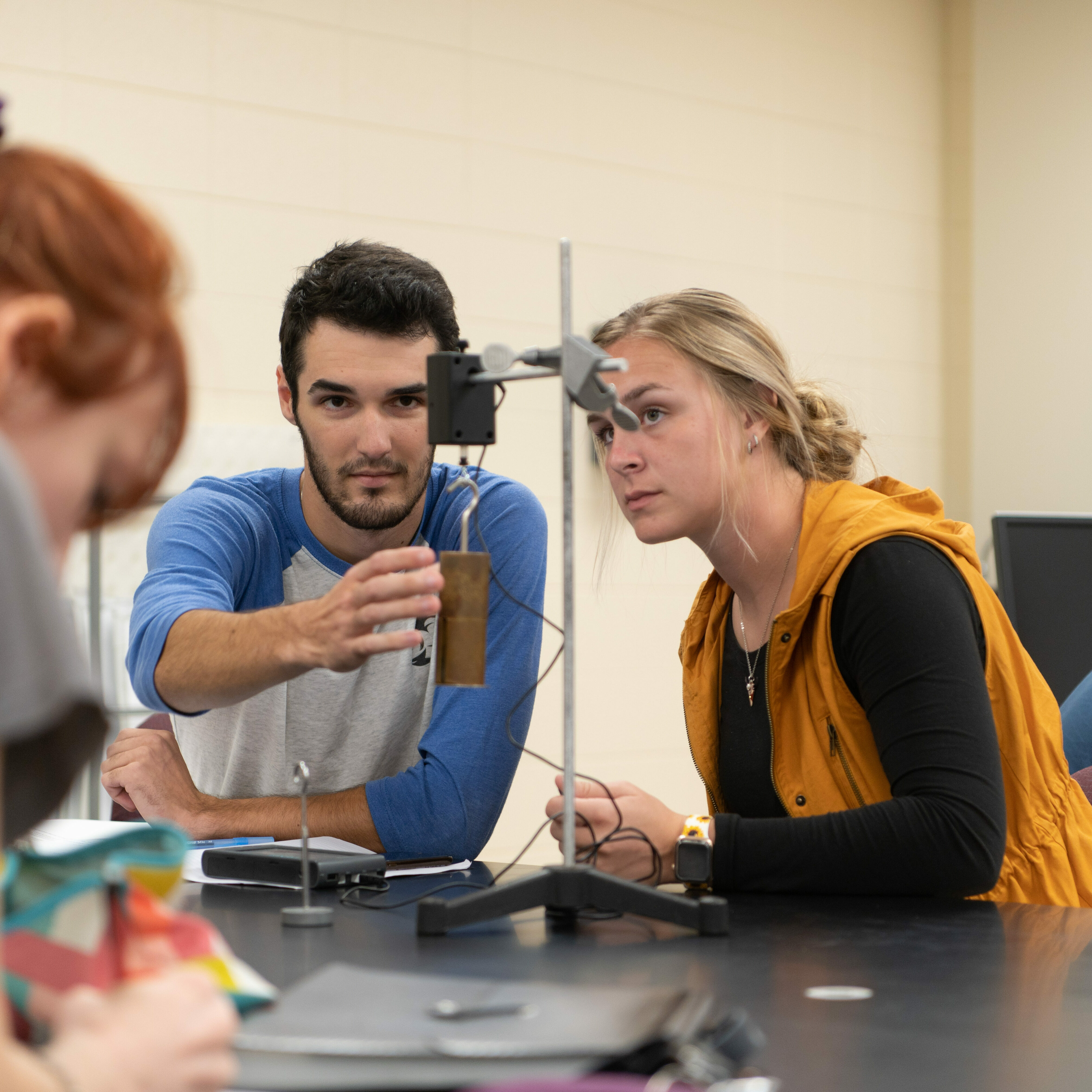 two physics students work on physics lab project