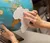 A student holds a paper cut out of the shape of Africa in front of a globe