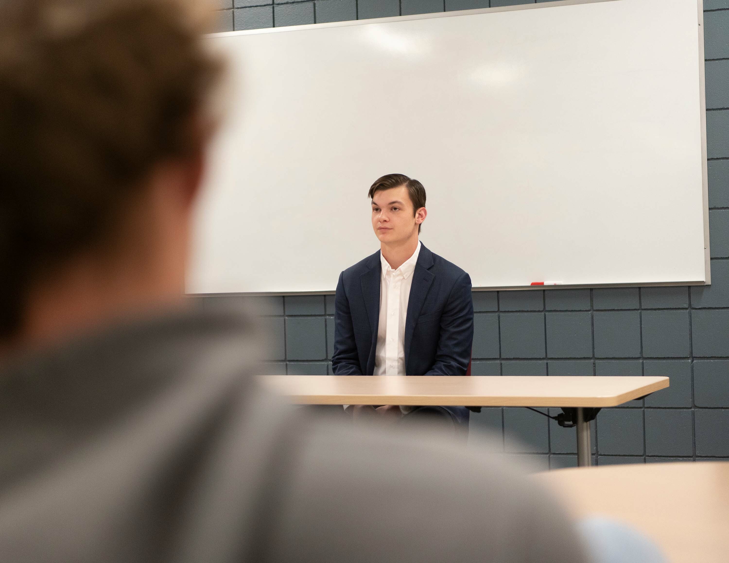 A male student sits in class like he's on the witness stand