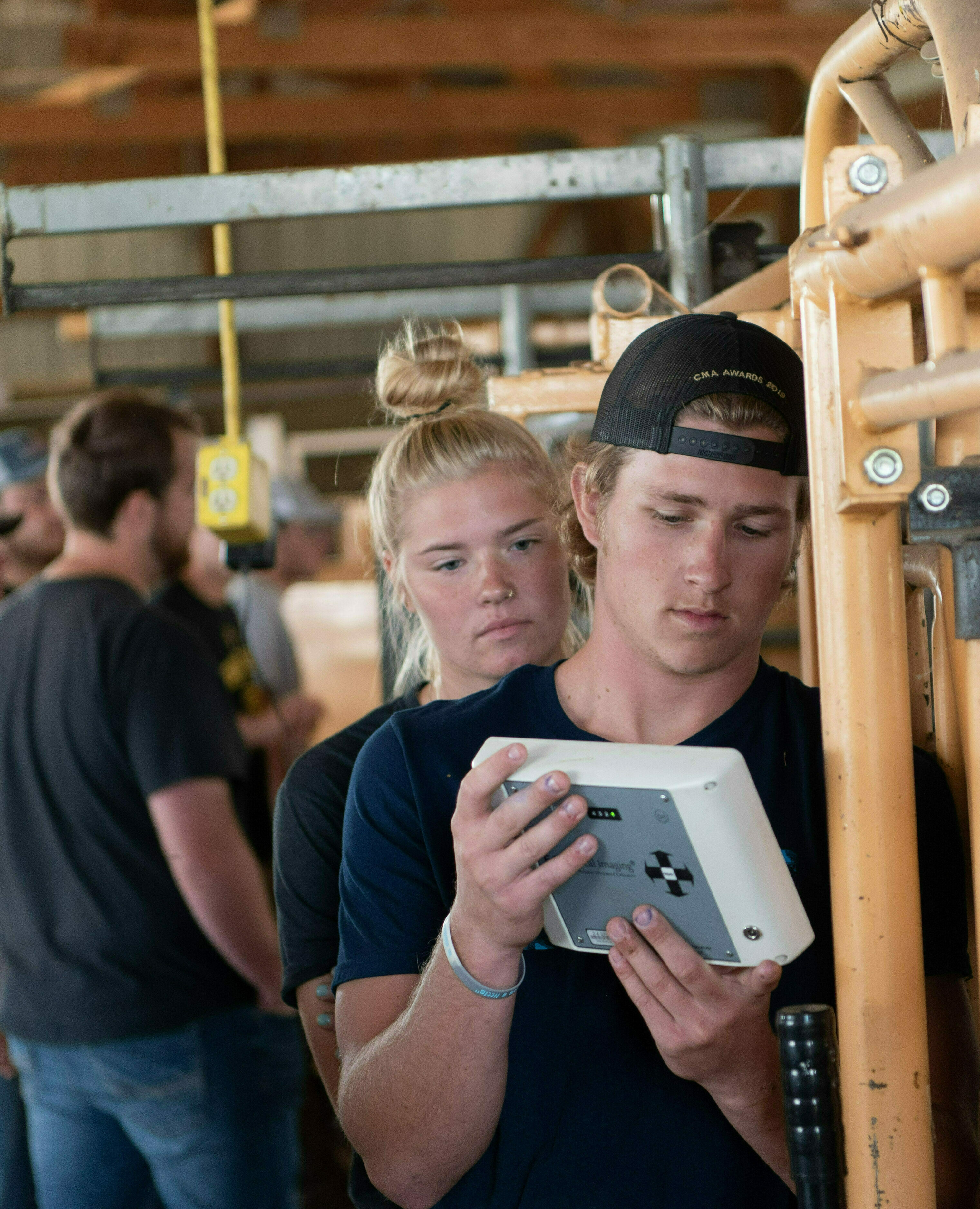 Two students read the measurements on a device