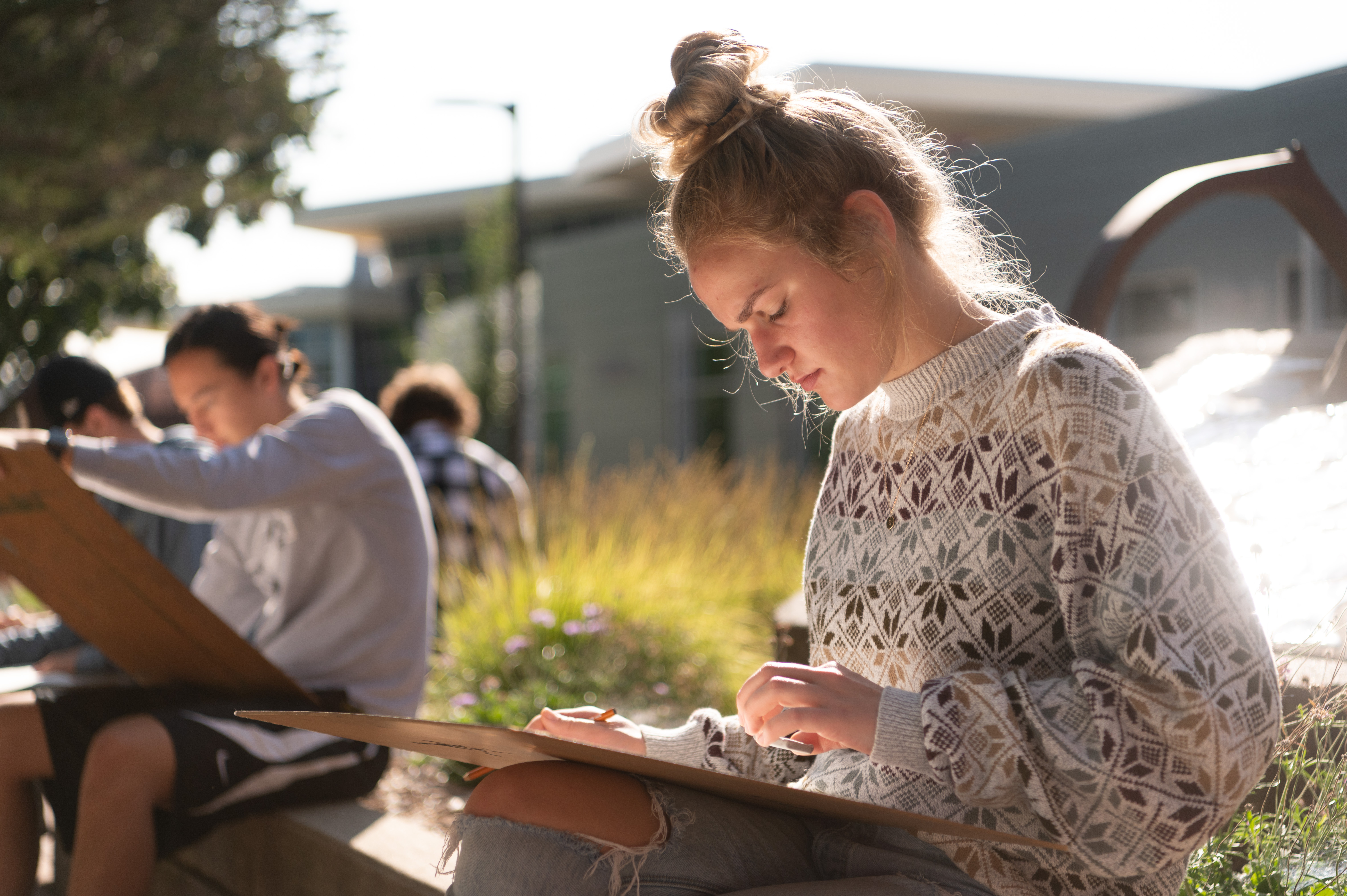 Female student working outside on a drawing