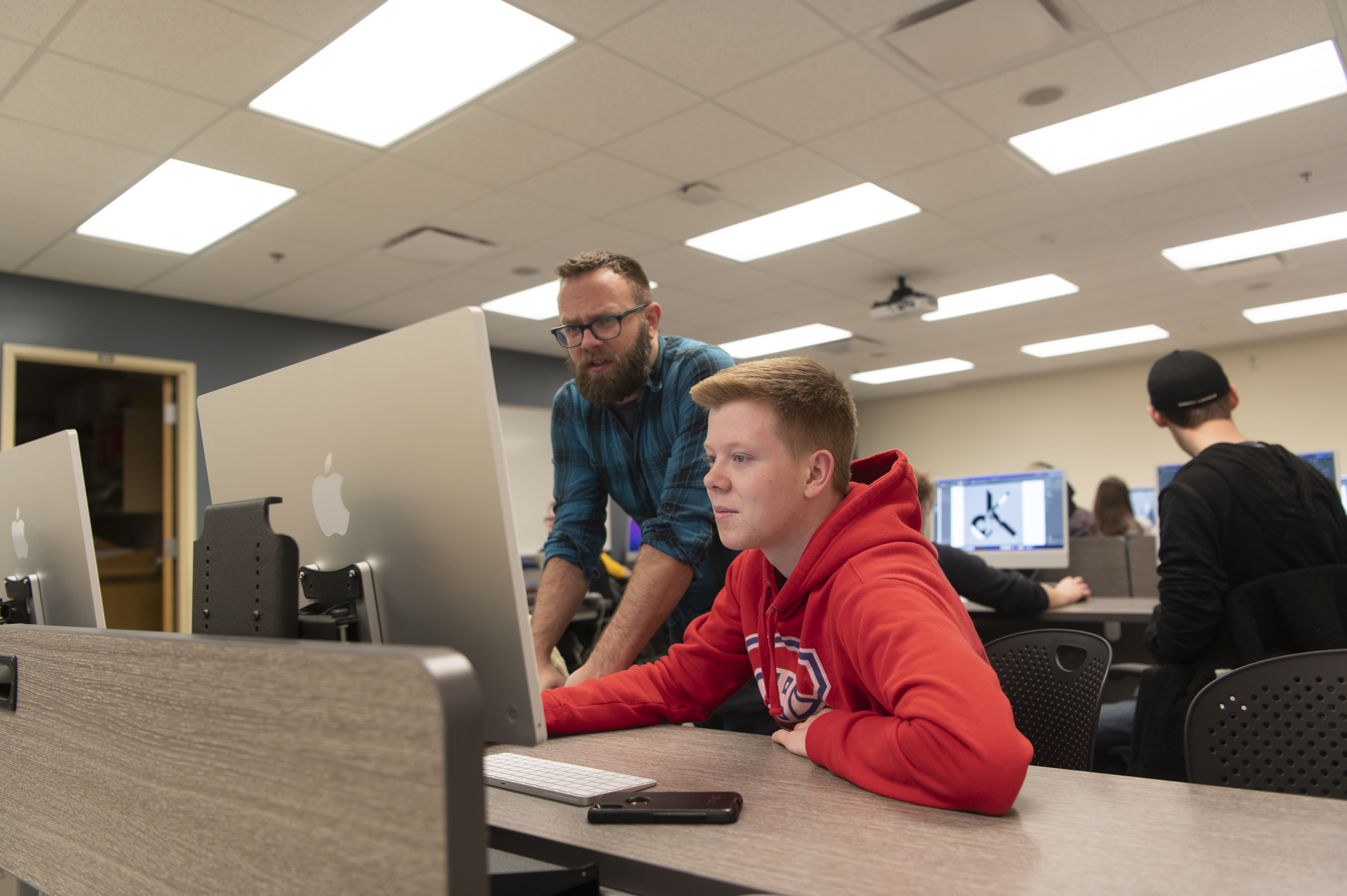Male student working with faculty member at a computer