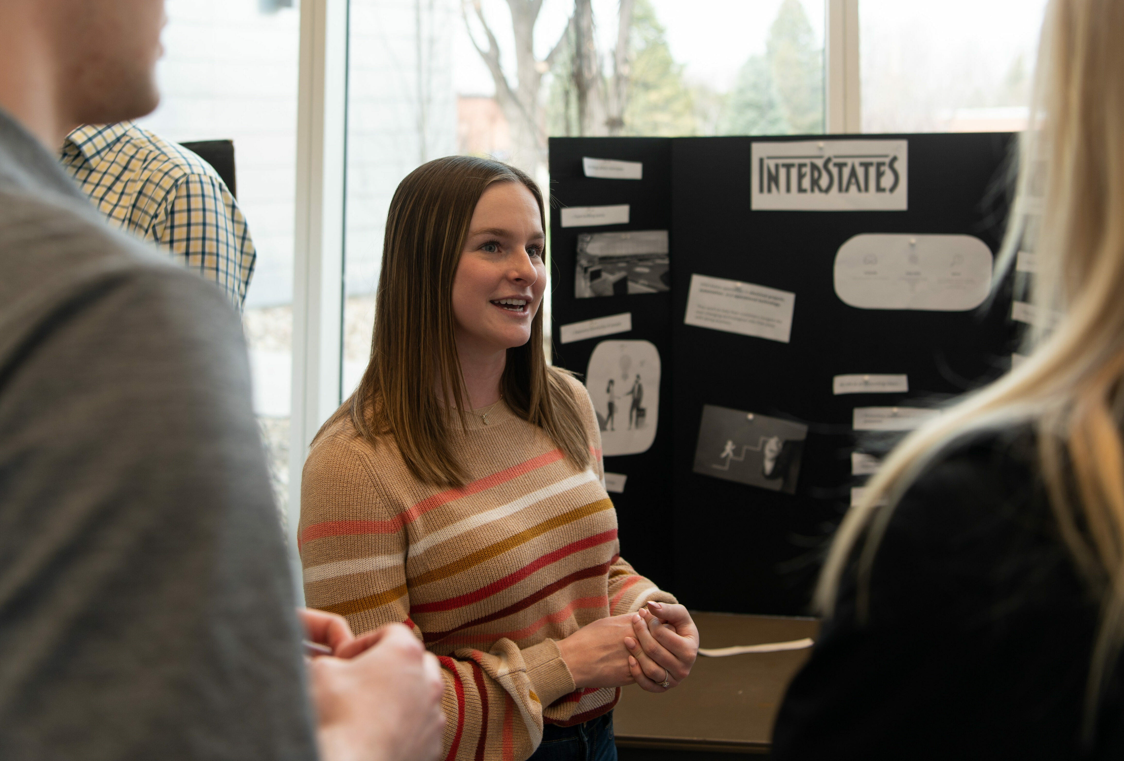Female student speaks with other students about a presentation