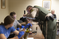 Sheriff working with student to fingerprint a bottle in the classroom