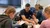 A male Dordt student sits among a group of elementary schoolers in class