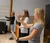 Three female students practice arm positions in conducting class