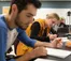 A picture of two students taking notes in a lab