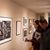 People look at drawings in an art gallary