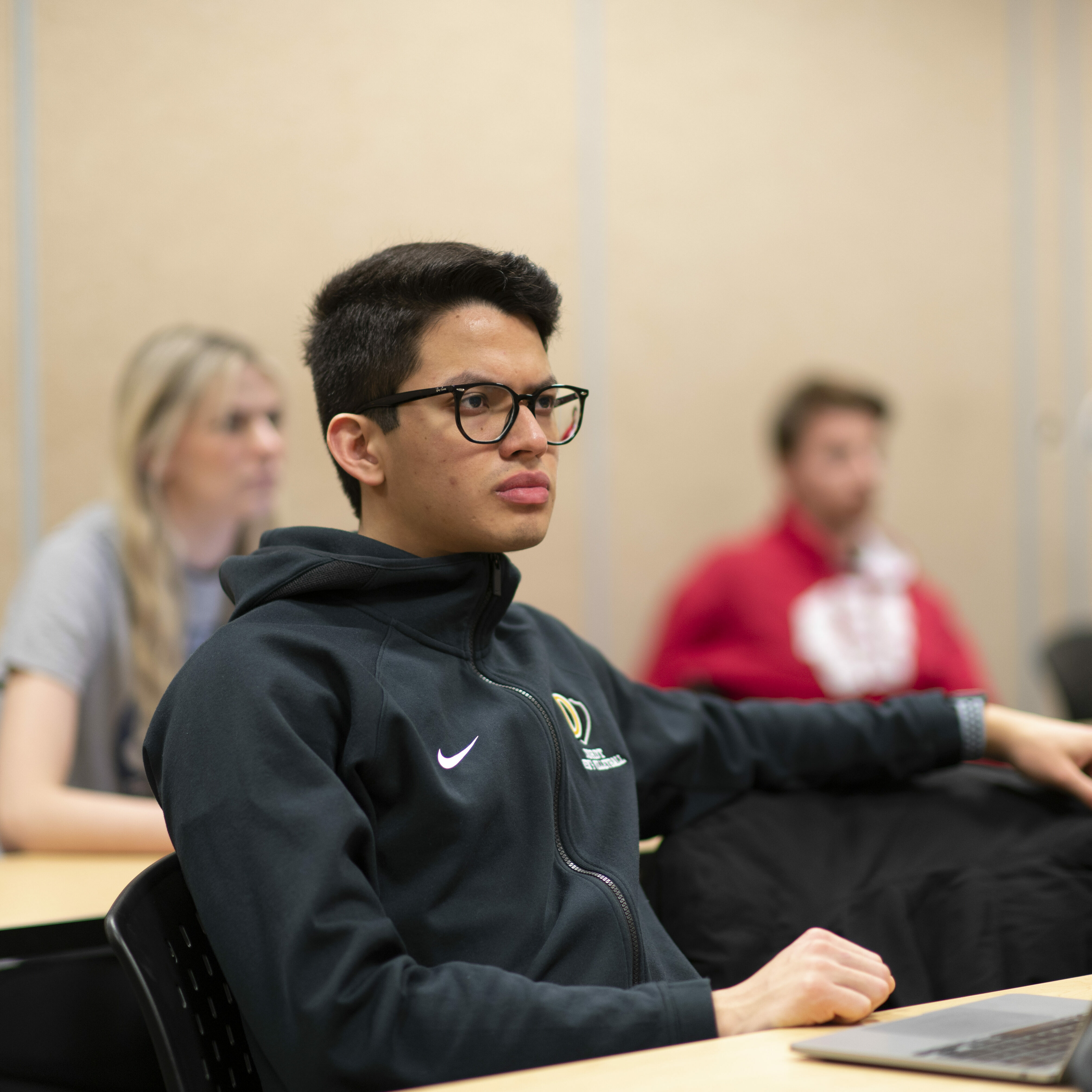 Male student sits in class and listens