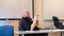 Male professor sitting in front of class