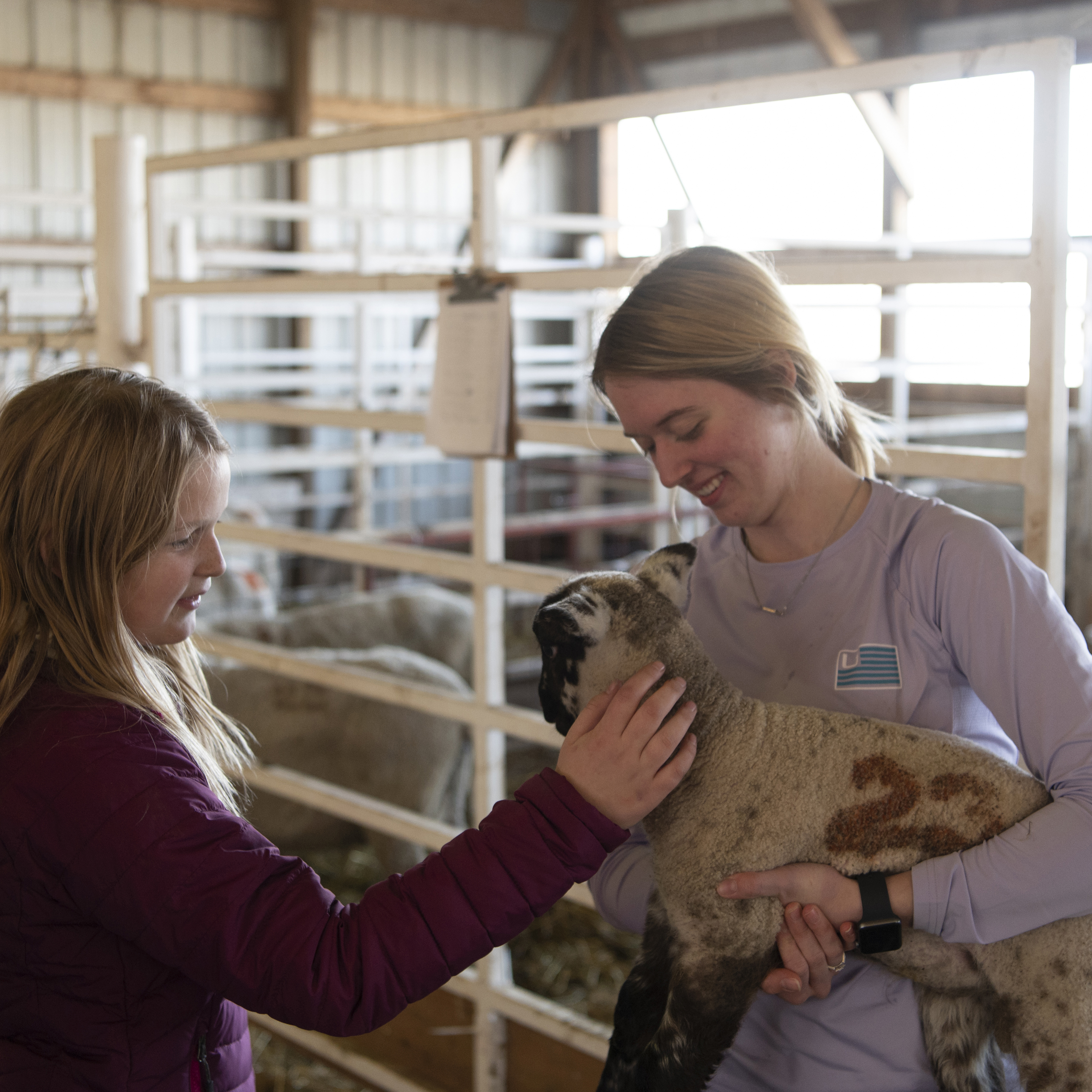 Female students hold sheep
