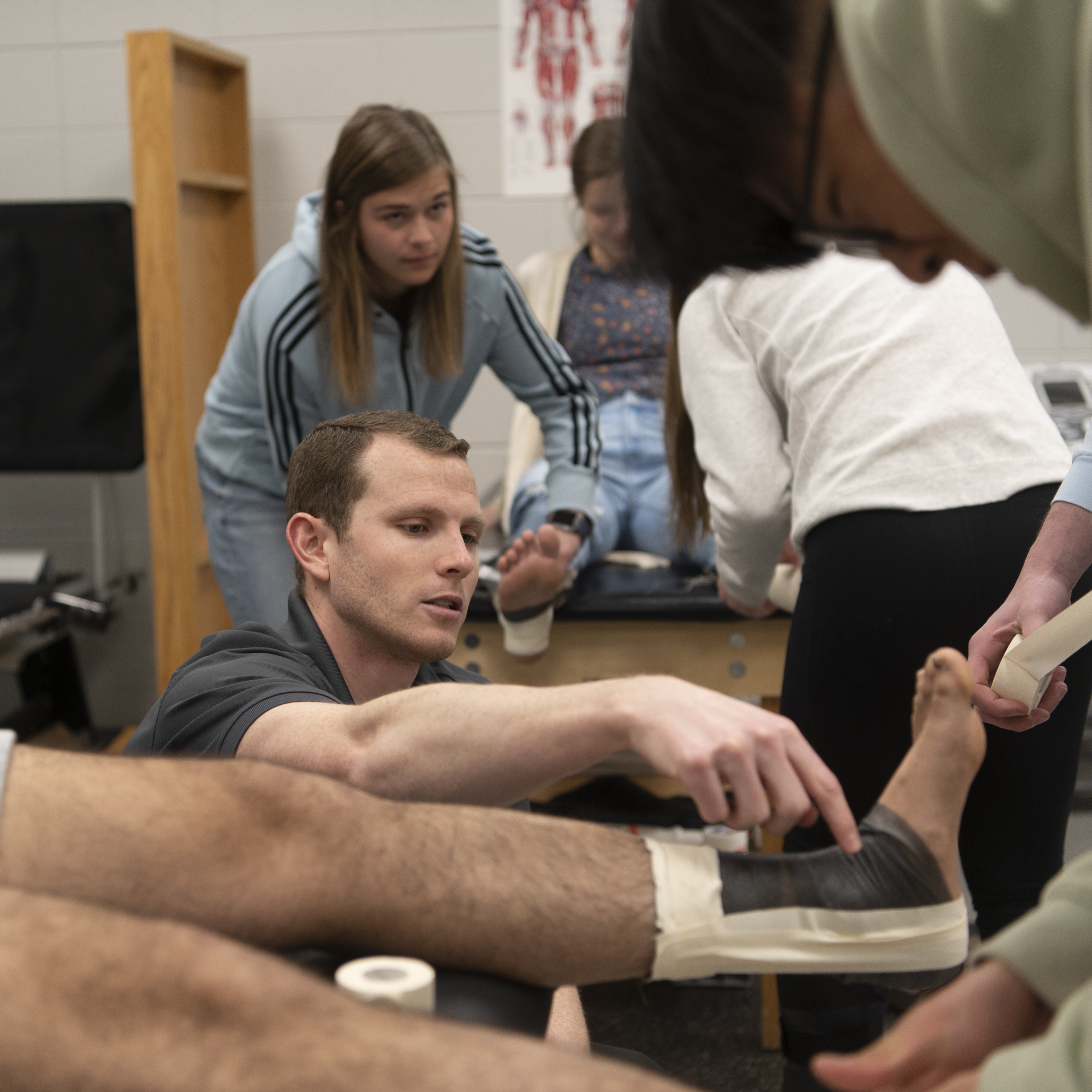 Students learning to tape a foot