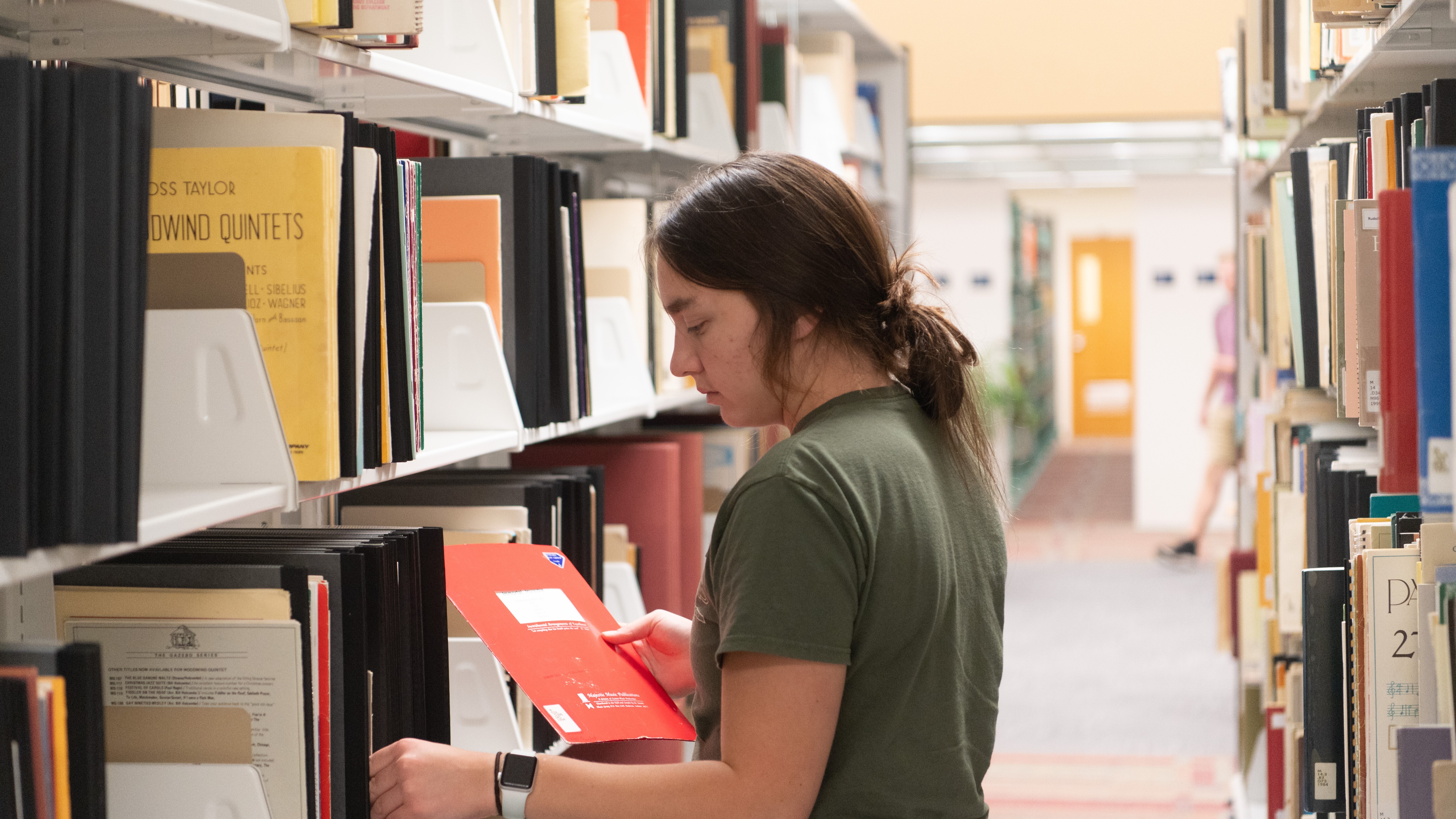 Female student looking at bookshelves
