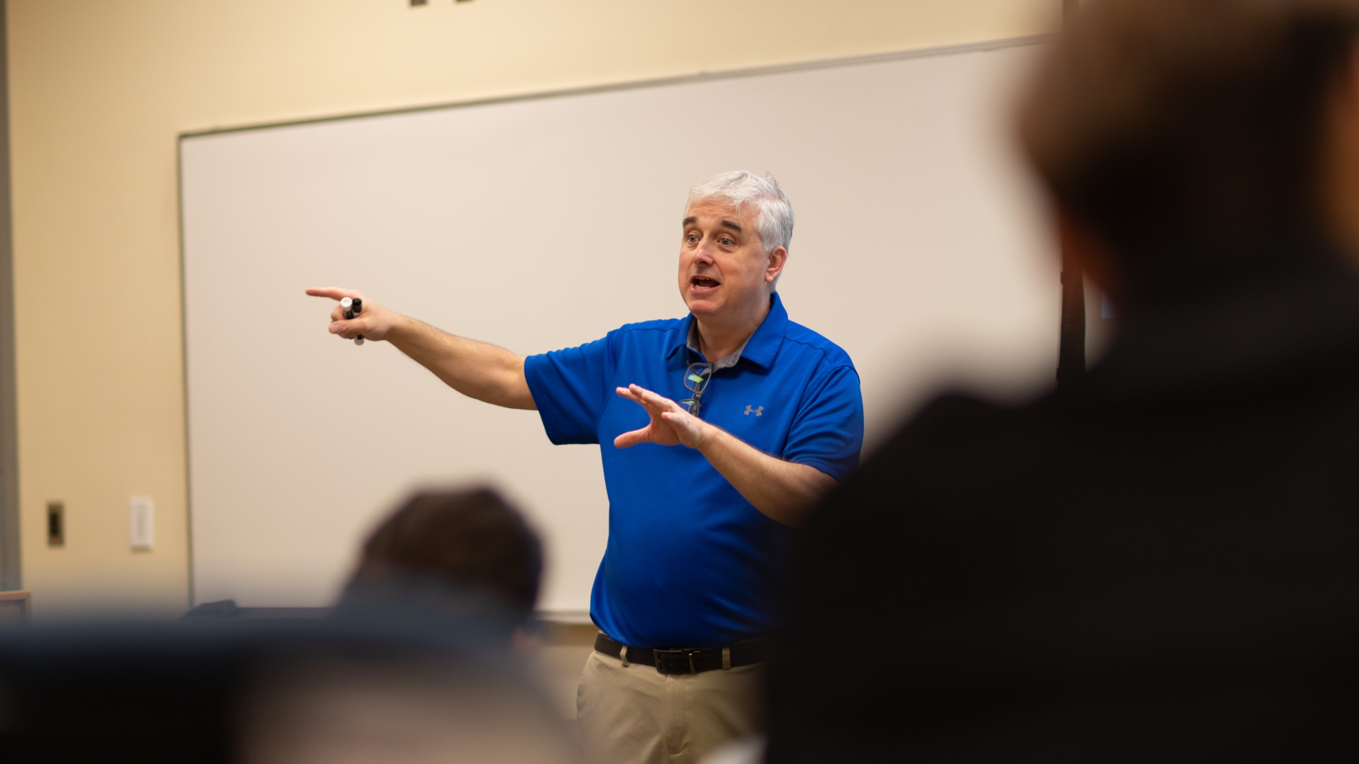 Male professor speaks in front of classroom