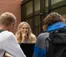 Students sit at a picnic table and study together.