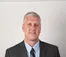 Ross Douma posing for a picture while wearing a suit.