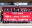 Runners stand with a banner and a national champions trophy