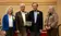 Four award recipients stand together with the award.