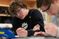 male student writing on paper