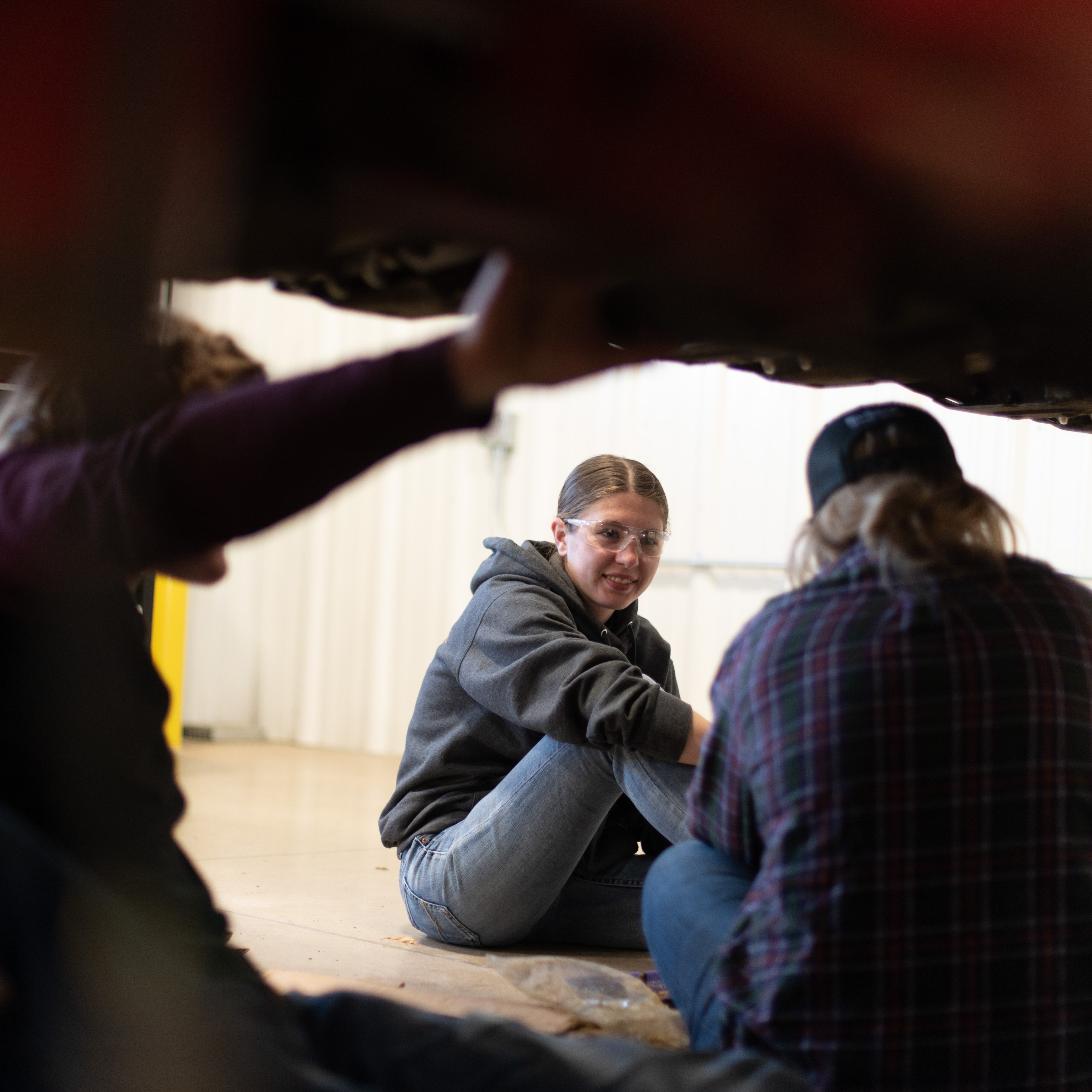 Female sits under machinery to learn