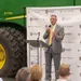 President Hoekstra addresses crowd on stage in front of John Deere equipment