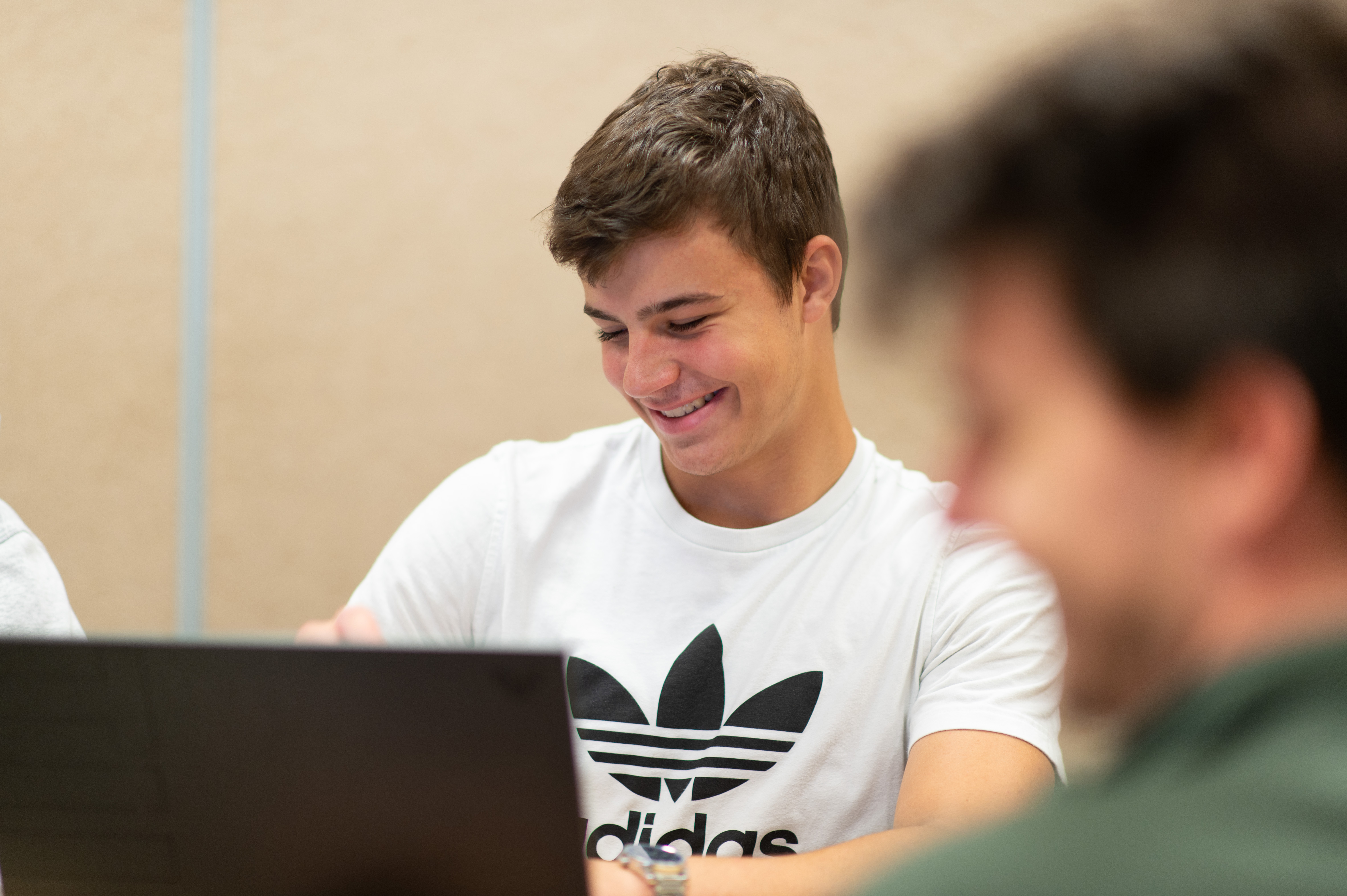Male student smiles at his computer